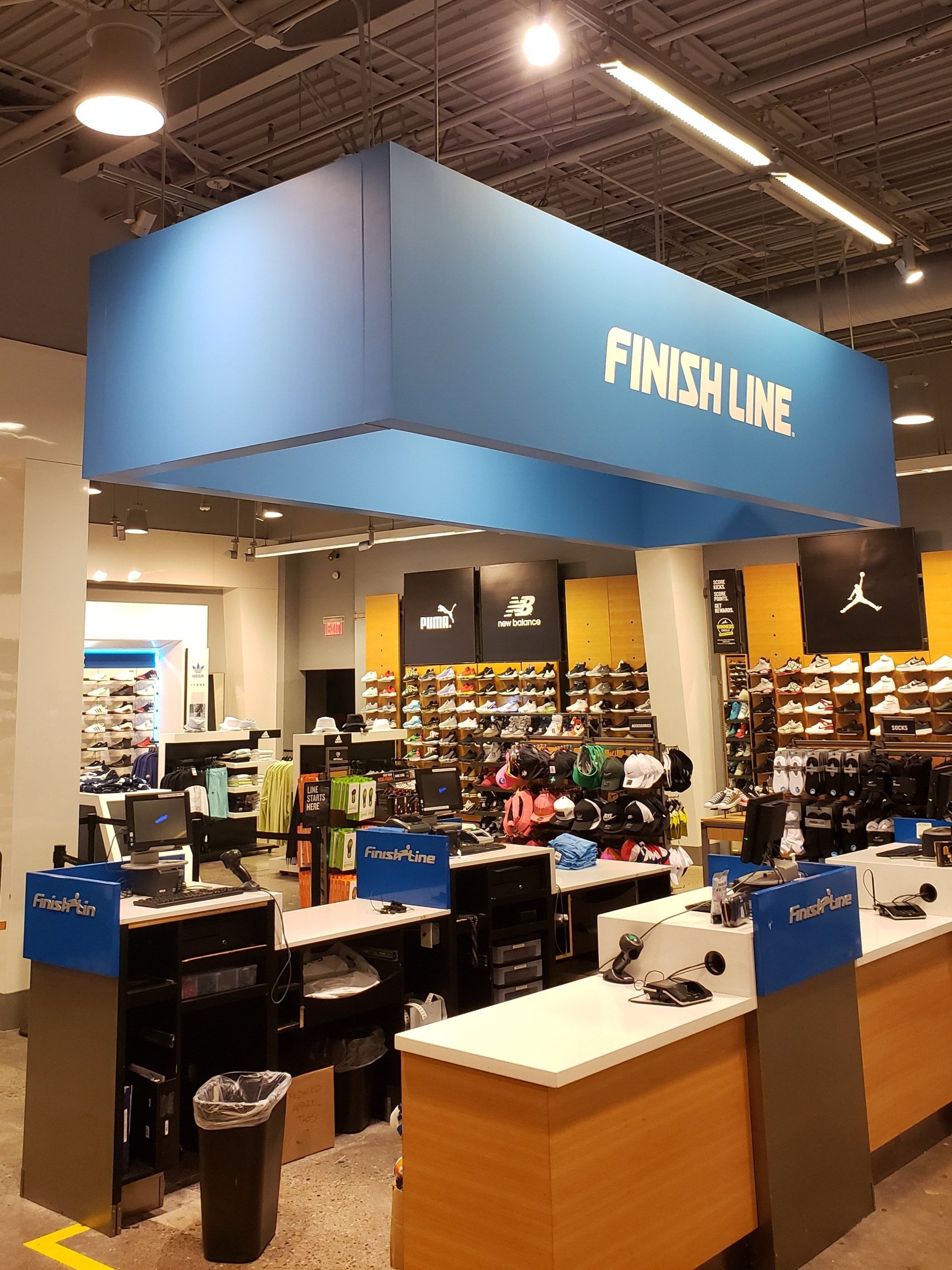 Finish Line retail store interior with cash registers, sneakers, and apparel displays.